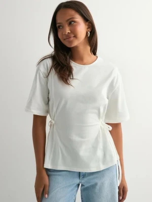 Vit t-shirt med knyt i sidan - Superfin vit t-shirt med korta ärmar och rund halsringning. T-shirten har snygga knytband på sidorna som ger form. Den är tillverkad av mjuk bomull. Använd ett fåtal gånger, storlek S💕