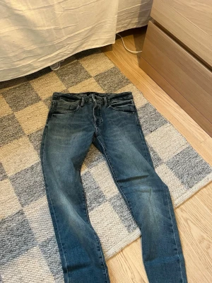 Blå slim jeans från Neuw - W34 L32 Snygga blå jeans från Neuw med klassisk femficksmodell och slim passform. Jeansen har en lätt tvättad look med subtila slitningar och är tillverkade i bomull. Perfekta för en avslappnad och trendig stil. Skriv om du har några frågor!😁