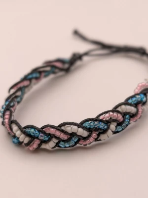 Flätat armband med pärlor - Snyggt flätat armband med små pärlor i blått, rosa och vitt. Armbandet har en svart tråd som bas och justerbar knytning för perfekt passform. Perfekt accessoar för dig som gillar färg och detaljer.