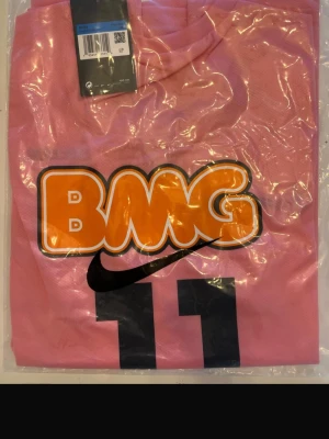 Santos rosa Neymar jr tröja 2012/2013 - Helt ny ! Cool rosa t-shirt från Nike med stort BMG-tryck i orange och svart framtill samt siffran 11. Perfekt för dig som gillar sportig och trendig stil. Neymar JR