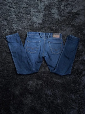 Blå slim fit jeans från Replay - Säljer ett par klassiska blå slim fit jeans från Replay med fem fickor och normalhög midja. Jeansen har en snygg tvätt. Perfekta för en avslappnad och trendig look. Pris kan diskuteras.