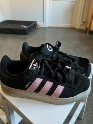 Adidas Campus svart/rosa sneakers - Säljer mina adidas campus på grund utav att jag inte har någon användning för de längre!☺️ De har några små fel som man kan se på bilderna men annars är de fortfarande i super bra skick! (På bilderna ser de ganska smutsiga ut på grund utav ljuset!) Bara använt ett par månader!