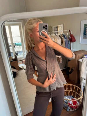 Grå stickad kofta med puffärmar ärmar - Säljer en grå stickad kofta med korta puffärmar och v-ringning. Koftan har ett strukturerat mönster och knappar framtill. Perfekt för lager-på-lager och ger en avslappnad men trendig look.⭐️