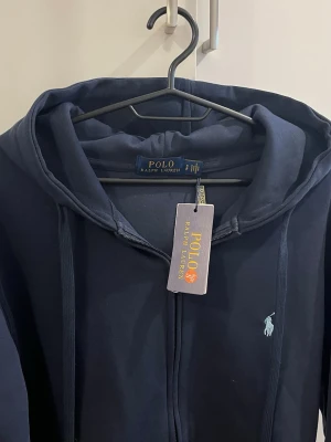 Raulph raulen zip  - Säljer en helt ny tröja då jag råkat köpa fel färg, den är marinblå och har märkets färg i ljusblå