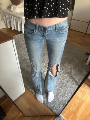 Lågmidjade jeans - Lågmidjade jeans med hål💕 Har sytt in dom lite i midjan vilket syns på sista bilden. Midje mått = 38 Innerbenslängd = 80