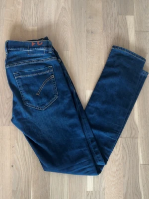 Dondup George jeans - Säljer ett par riktigt schysta mörkblå dondup jeans i storlek 31 klassisk femficksdesign och diskreta slitningar. Dom  är gjorda i stretchig denim för extra komfort. Perfekta för dig som gillar en stilren och modern look. Priset kan såklart diskuteras 🤝om ni har någon som helst fråga eller vill ha fler bilder  så svarar jag snabbt ☺️