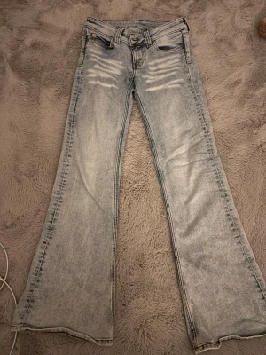 Bootcut jeans från Cheap Monday - Ljusblå bootcut jeans från Cheap Monday med slitna detaljer framtill och klassisk femficksdesign. Jeansen har en lätt utsvängd passform nertill och är tillverkade i bomull med lite polyester och elastan för stretch.