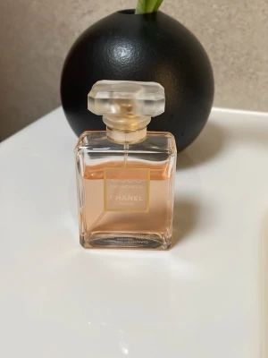 Chanel Coco Mademoiselle parfym - Chanel Coco Mademoiselle parfym i en elegant, rektangulär glasflaska med guld- och vit etikett. Ljusrosa doftvätska och en lyxig, frostad fyrkantig kork ger en exklusiv känsla. Perfekt för dig som gillar klassiska och sofistikerade dofter.