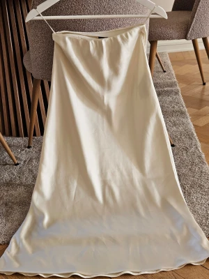 Cremevit satinkjol - Satin midi vadlång kjol, storlek 34. Krämfärgad 