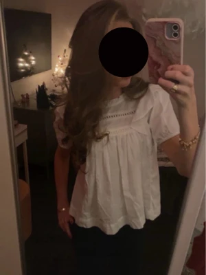 Vit blus med spetsdetaljer - Söt vit blus med korta ärmar och dekorativa spetsdetaljer upptill. Endast använd 1 gång! ❤️