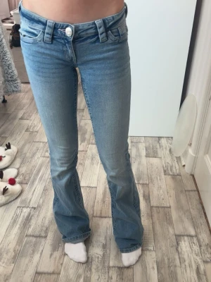 Blåa lågmidjade jeans  - Jag säljer ett par lågmidjade jeans ifrån Gina Tricot, från deras young 14+ i storlek XS. De är i jättefint skick och använda 1-3 gånger. 