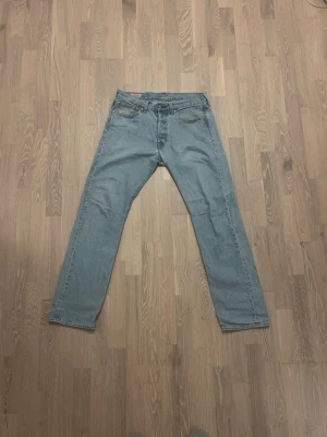 Levi’s 501 Ljusblå - Storlek W31 L32 - Säljer ett par ljusblå jeans med rak passform och klassisk femficksdesign. Jeansen har normal midja och är tillverkade i denim. Perfekta för en avslappnad och stilren look.