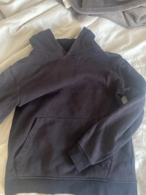 Svart hoodie med magficka - En enkel svart hoodie med huva och stor magficka framtill. Tröjan har ribbade muddar vid ärmslut och nederkant för en skön passform. Tillverkad i mjukt bomullsliknande material, perfekt för en avslappnad stil. Pris kan disskuteras!💗