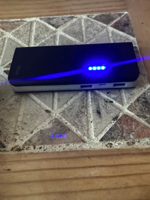 Svart powerbank från Trust - Powerbank i svart och silver från Trust med två USB-portar och LED-indikatorer som visar batterinivå. Perfekt för att ladda mobilen eller andra prylar på språng. Smidig, rektangulär design i plast.
