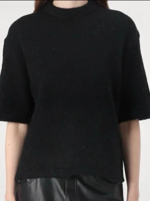 Svart stickad tröja Gina Tricot - Svart stickad tröja från Gina Tricot i ullblandning. Tröjan har halvlånga ärmar, rak passform och rund halsringning. Perfekt för lager-på-lager och enkel att matcha med olika stilar.