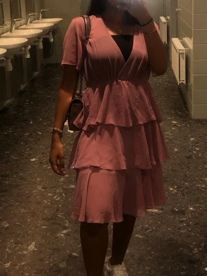 Sommar klänning - Säljer en ljusrosa klänning. Den har flera lager volanger och korta ärmar. Materialet är lätt och luftigt, perfekt för sommaren eller midsommar. Använd en gång 