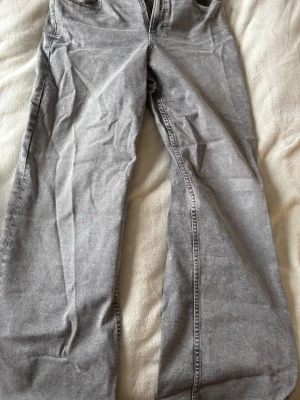 Grå raka jeans från ginatricot  - Snygga grå jeans från Perfect Jeans i rak modell. Jeansen har klassisk femficksdesign, dragkedjegylf och knapp framtill. Materialet är denim med en tvättad look som ger en avslappnad vibe. Storlek 42