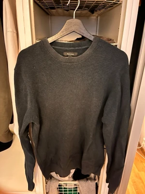 Mörkblå stickad tröja - En enkel och stilren mörkblå stickad tröja. Tröjan har rund halsringning, långa ärmar och är tillverkad i ett mjukt, ribbstickat material. Perfekt för lager på lager och passar till det mesta. Bilderna är lite dåliga pga ljuset men tröjan är mörkblå. Storlek L men passar M