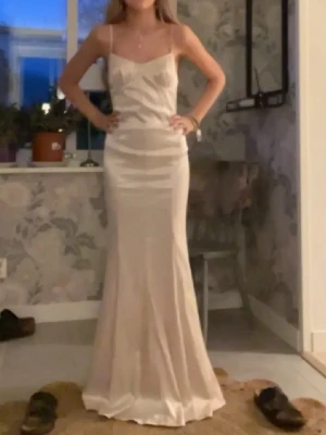 Champagnefärgad långklänning i satin - Säljer min balklänning jag använt endast en gång! Från naw-kd. långklänning i champagnefärgad satin 