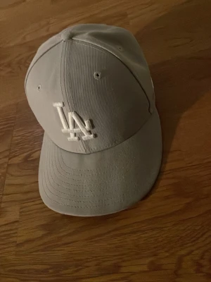 LA keps - La dodgers keps har använts ganska mycket men fortfarande väldigt snygg keps. Själv har jag böjt själva skärmen liksom. Tyckte det skulle se snyggare ut så. Den är 54.9 cm alltså ungefär 55 cm runt huvudet.
