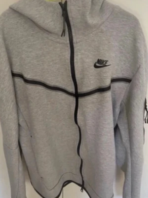 Grå Nike tech - Mycket bra skick! Nästan aldrig använd. Det är storlek S. Passar både tjejer killar. Den är äkta och köpt på JD sports hemsida för ca 1400kr. Skriv vid frågor! 