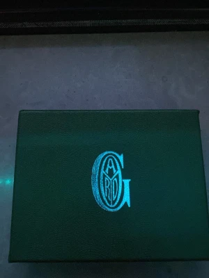 Grön korthållare  - Snygg grön korthållare med det klassiska mönstret och loggan framtill. Kommer i originalask med tillhörande certifikat. Tillverkad i exklusivt läder med vit text och detaljer. Perfekt för dig som vill ha något stilrent och lyxigt.