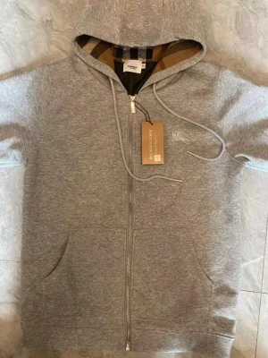 Burberry hoodie med dragkedja - Burberry hoodie i nytt skick. Finns i flera storlekar                         Skriv för mer information