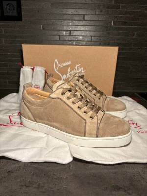Beige sneakers från Christian Louboutin - Stilrena beige sneakers från Christian Louboutin i mocka med vita gummisulor och matchande beige skosnören. Otroligt rare modell väldigt eftersökt. Storlek 43,5 sitter runt där 43-44,5, allt og finns som syns på bild 