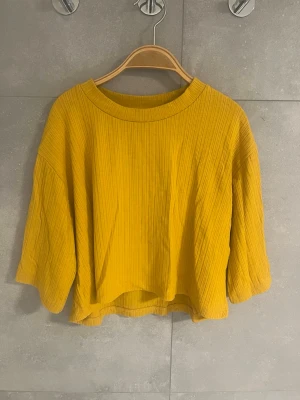 Gul croppad topp - Snygg gul croppad topp med vid struktur och lite längre T-shirt ärmar. Oversized så sitter bra på M också