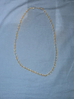 Tjockt silverhalsband i tvinnad kedja - Säljer ett stilrent halsband i äkta silver doppad alltså planterad med 925 stirling, stämplat 925. Kedjan är tvinnad och har en robust känsla som ger ett snyggt statement till din outfit. Perfekt för dig som gillar klassiska accessoarer med lite extra edge.