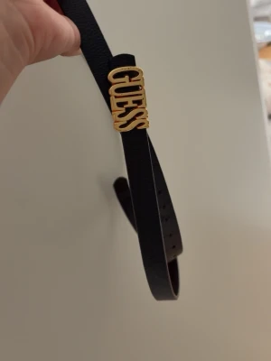 Bälte med detalj  - Fint svart med bälte med guldig detalj. Använt skick. Finns några repor på emblemet. Därav priset. 120cm 