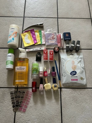 Stort skönhetspaket med blandade produkter - Ett stort paket med skönhetsprodukter som inkluderar fotbad, duscholja, ögonmasker, nagellack i flera färger, läpprodukter, ögonskugga, deodorant, exfolierande strumpor, nageldekorationer och smink från märken som Cien, Eucerin och Vichy. Perfekt för dig som vill testa olika produkter inom skönhet.