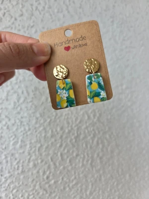 Handgjorda örhängen med citronmotiv - Unika handgjorda örhängen med guldfärgade, hamrade plattor och hängen med citronmönster. Örhängena är gjorda för hand av mig i polymerlera. 