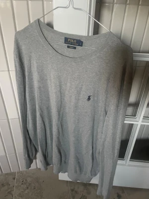 Grå tröja från Polo Ralph Lauren - Snygg grå långärmad tröja från Polo Ralph Lauren i slim fit-modell. 