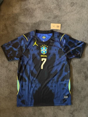 Brasilien VM 26/27 borta  Vini JR 7 - Fotbollströja med Vini JR på ryggen. Tröjan är helt ny med tagg kvar och i perfekt skick. Storlek M. Perfekt för dig som är supporter, samlar på fotbollströjor eller vill ha en snygg tröja till träning och vardag. 🔹 Storlek M 🔹 Helt ny med tagg 🔹 Vini JR 🔹 Skickas inom 24 timmar Vid intresse eller frågor är det bara att skicka 👍