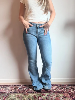 Blåa bootcut jeans  - Säljer dessa supersnygga, medelhögmidjade, blåa, bootcut jeans från Mango i storlek 36. Jeansen är i ett mycket bra skick och endast använda ett fåtal gånger.