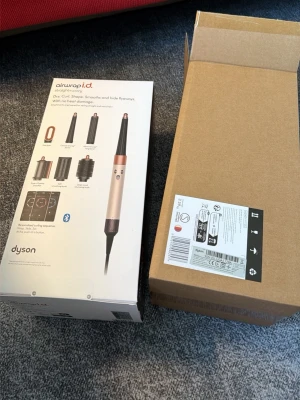 Dyson Airwrap i.d. hårstyler - Dyson Airwrap i.d. är en multifunktionell hårstyler i roséguld och svart. Den har flera utbytbara tillbehör för att torka, locka och forma håret utan värmeskador. Bluetooth-funktion för personliga stylinginställningar. Perfekt för att skapa olika frisyrer.