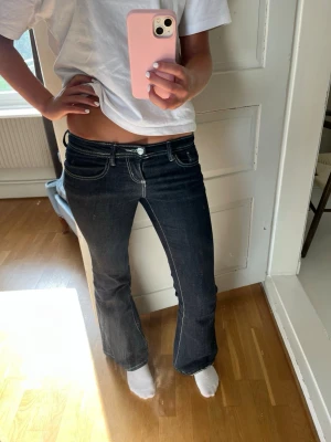 Mörkblå bootcut jeans med kontrastsömmar - Säljer ett par mörkblå bootcut jeans med vita kontrastsömmar och låg midja. Dom passar mig i längden som är 1.68💕💕💕