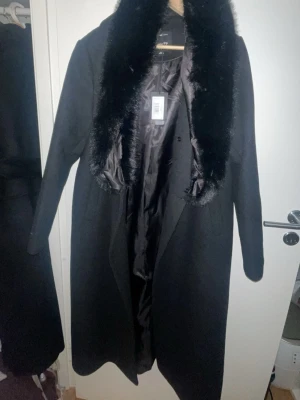 Svart kappa med fuskpäls  - Nyköpt svart kappa med fuskpäls Storlek 40/42