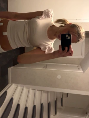 Vit croppad topp med puffärm Gina Tricot - Säljer en vit croppad topp från Gina Tricot med puffiga korta ärmar och ribbad struktur. Perfekt för dig som gillar en enkel men trendig stil. Toppens passform är tight och den är tillverkad i mjuk bomull.