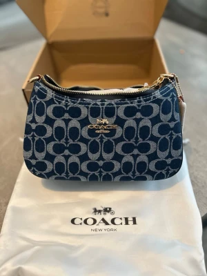 Coach Signature Mini Shoulder Bag  - Säljes nu en Coach Signature Mini Shoulder Bag i väldigt fint skick då den aldrig använts! Orginal karton samt orginal detaljer och tillbehör följes med! För mer frågor och info hör gärna av dig så svarar jag så gott jag kan💕