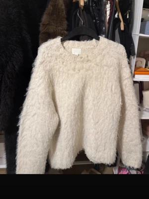 Vit fluffig stickad tröja - Supermjuk och fluffig vit stickad tröja med rund hals och avslappnad passform. Materialet är lurvigt. Tröjan är från HM och är i storlek S! Skriv om du undrar något!