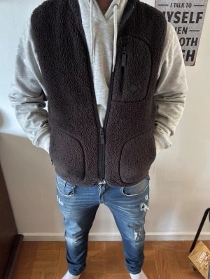 Svart J.Lindeberg fleeceväst - Säljer nu min L.Lindeberg fleece väst i färgen svart. Storleken är S. Jag på bilden är 177 och väger 77 kg. Västen är inprincip i ny skick och är knappt använd. Skriv för fler frågor 
