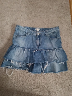 Jeanskjol - Jeanskjol med vollanger från Gina Tricot young i storlek 170 men sitter som xs/s. Resårband med knappar på insidan som brukar finnas på jeans till barn så man kan spänna åt. 💞