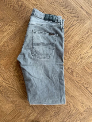 Grå nudie grim Tim - Nudie grim Tim i storleken 33 34. Sparsamt använda och i nyskick. Skriv vid minsta fundering! MVH Hugos closet