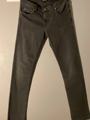Svarta jeans från J.Lindeberg - Stilrena svarta Slim Jeans från J.Lindberg😎. Inga skador och är så gott som nya🕺. Nypriset ligger 1200kr- 1500kr. Mitt pris är 450kr🤩. Säljer för att de är för små för mig.