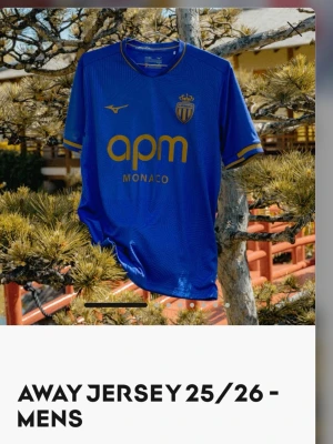 AS Monaco blå bortatröja Mizuno M - Säljer en blå AS Monaco bortatröja för säsongen 25/26 från Mizuno. Tröjan har guldiga detaljer och klubbens emblem på bröstet samt sponsorlogga framtill. Tillverkad i funktionsmaterial, perfekt för fotboll eller träning.