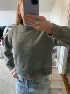 Grå stickad tröja från Bik Bok - Mjuk och mysig grå stickad tröja från Bik Bok i alpaca blend. Tröjan har en rund halsringning, ribbstickade muddar och är lite kortare i modellen.