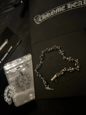 Chrome Hearts silverarmband - FÖR EN ARMBAND ELLER RING ÄR PRISET!!! Snyggt armband från Chrome Hearts i äkta silver med ikoniska korsblommor som länkar. Armbandet har en cool och detaljerad design med gravyr på låset. Perfekt för dig som gillar streetwear och exklusiva accessoarer.