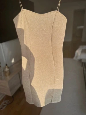 Glittrig klänning  - En glittrig champagne/beige färgad glitter klänning från Nelly